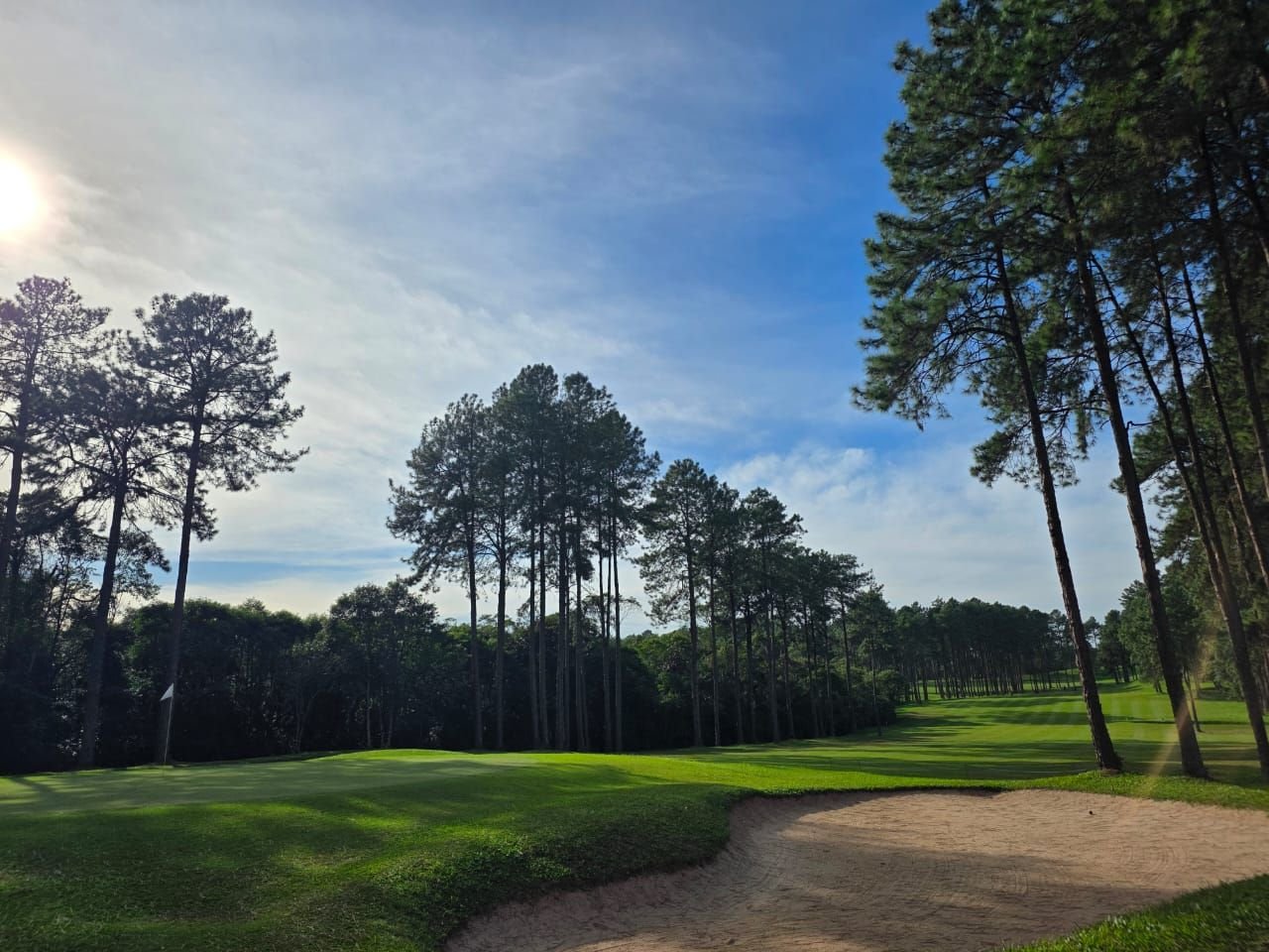 Green com bandeira e bunker de areia em primeiro plano